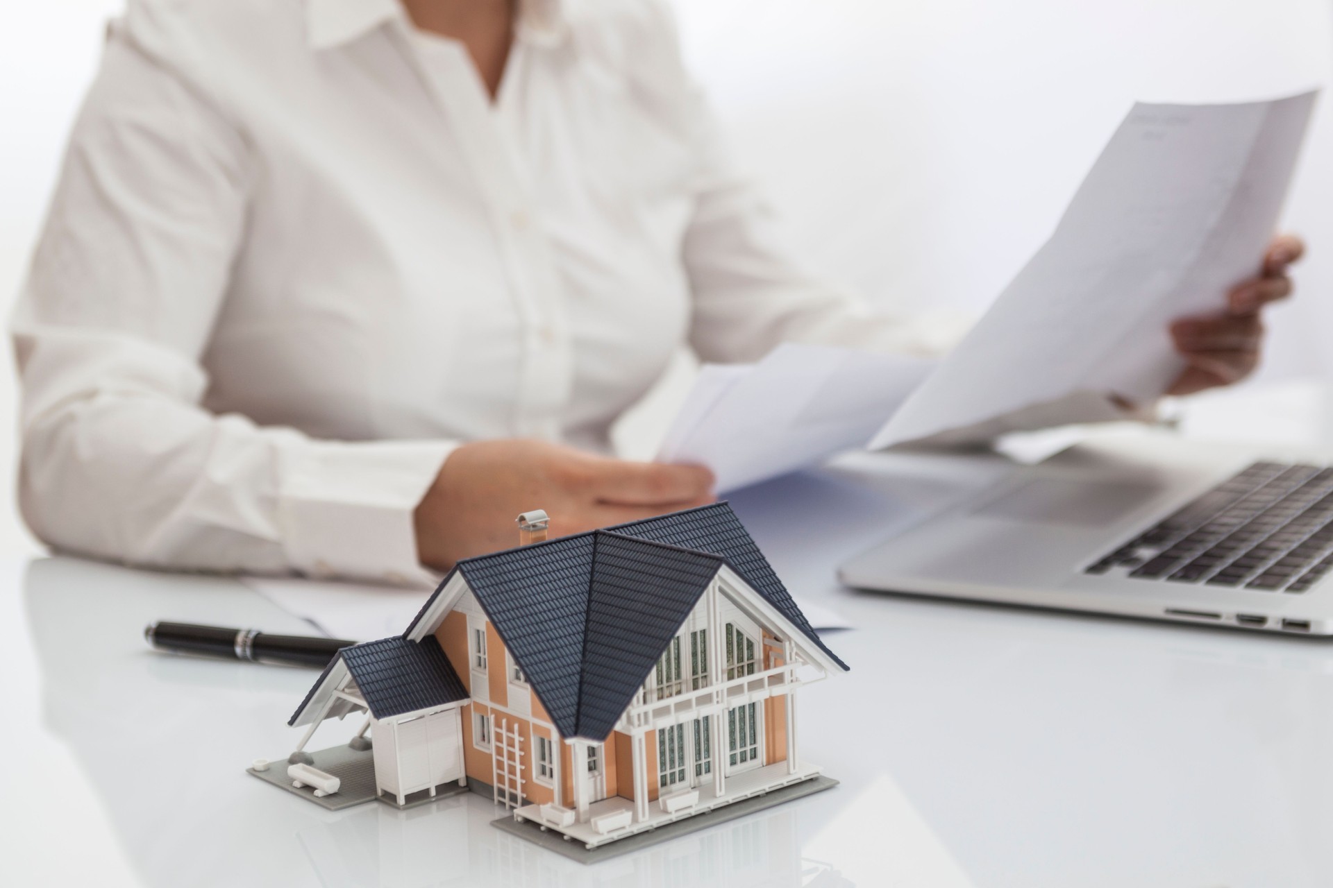Real estate agent or custumer reading purchase agreement for new house in the office